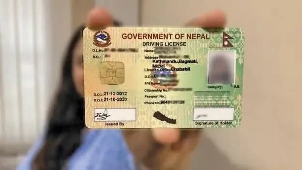 A person holding a Nepali driving license.