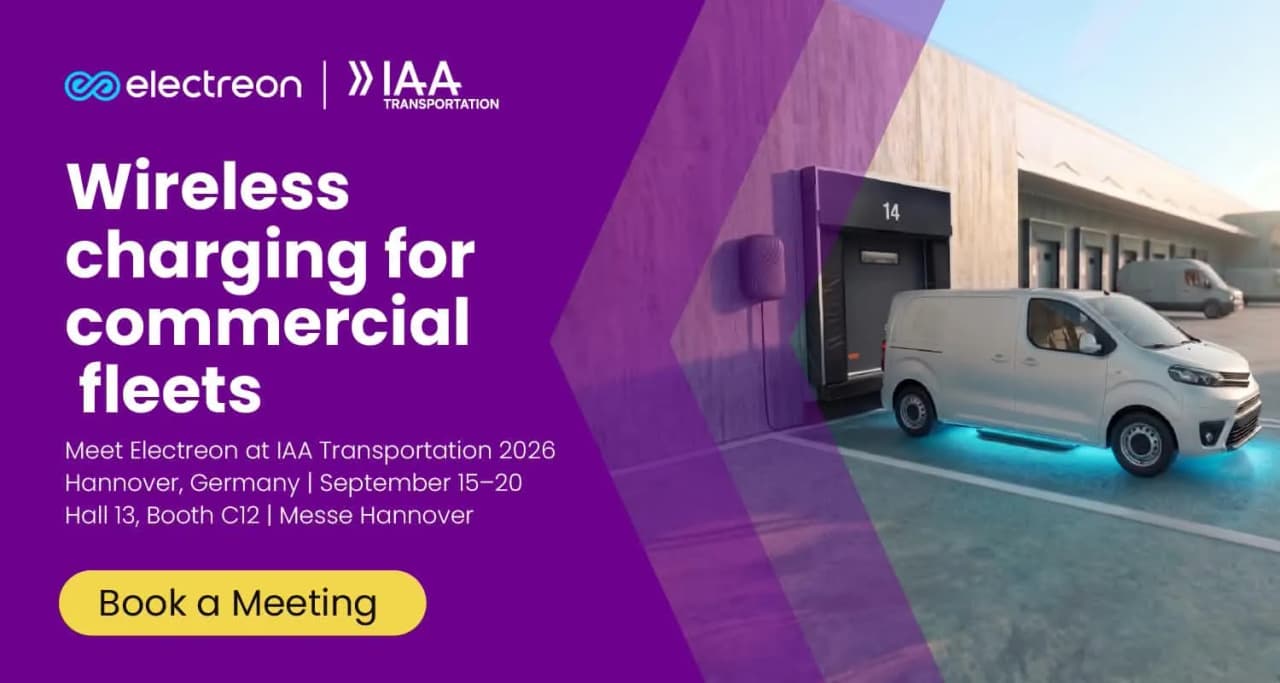 A white electric commercial vehicle parked over a wireless charging pad.