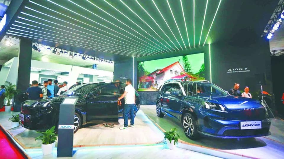 Two AION electric vehicles displayed at an auto show.