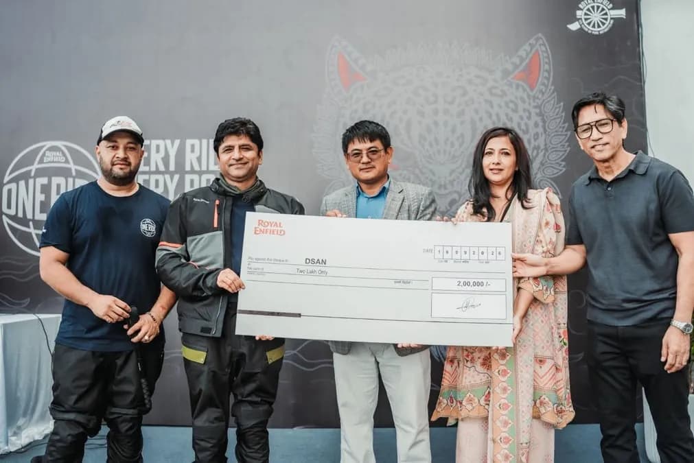 Group of individuals presenting a large cheque for Rs 2 lakh to support Down Syndrome Association Nepal during the Royal Enfield 'One Ride' event.