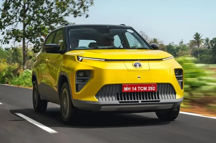 A yellow Tata Punch EV driving on a road.