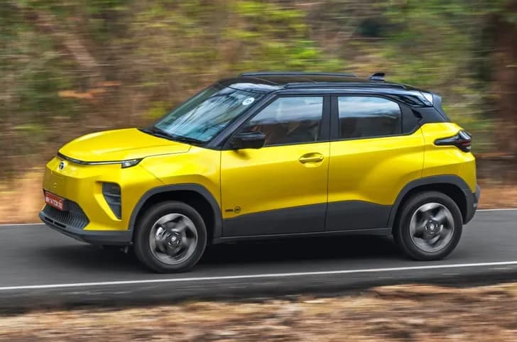 Tata Punch EV facelift in yellow color driving on a road.