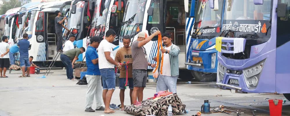 Workers performing rituals on buses during Vishwakarma Puja